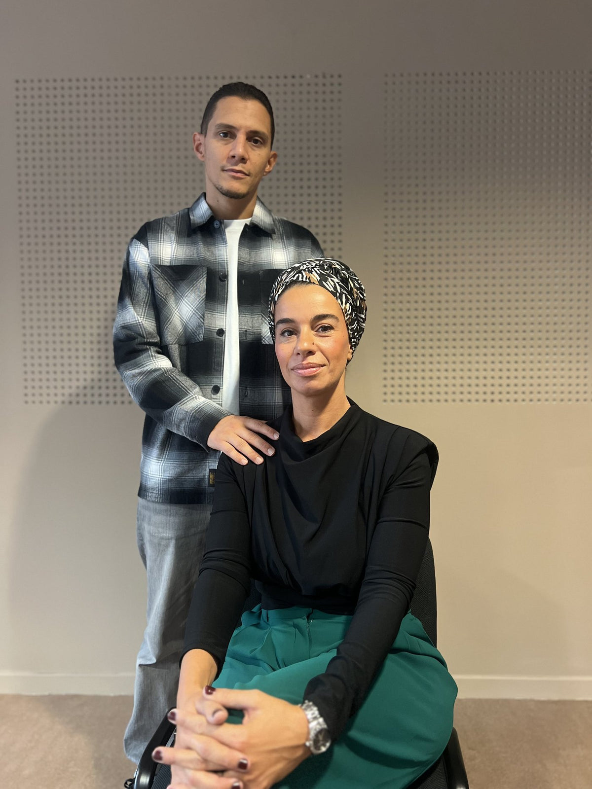 Chafia assise, Mehdi debout derrière elle, la main sur son épaule